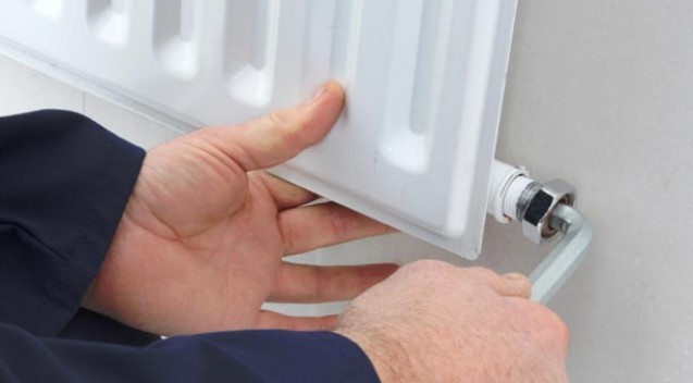 Engineer fitting a new radiator valve